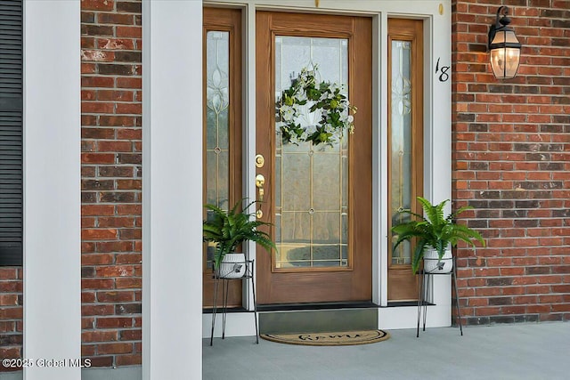 doorway to property featuring brick siding