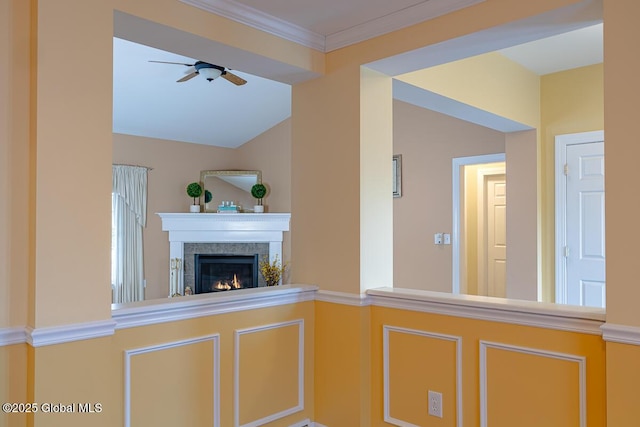 kitchen with lofted ceiling, ornamental molding, a lit fireplace, and ceiling fan