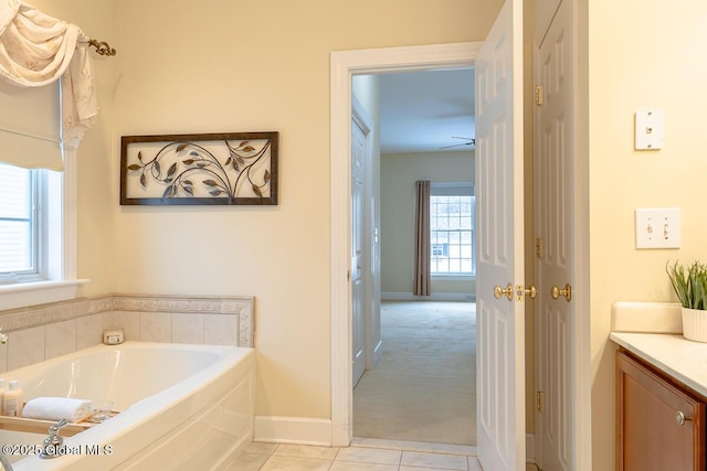 full bathroom featuring baseboards, a garden tub, vanity, and tile patterned flooring