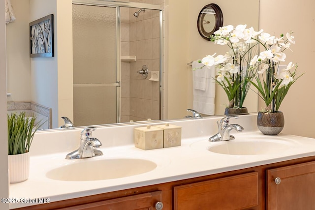 full bathroom featuring a sink, a stall shower, and double vanity