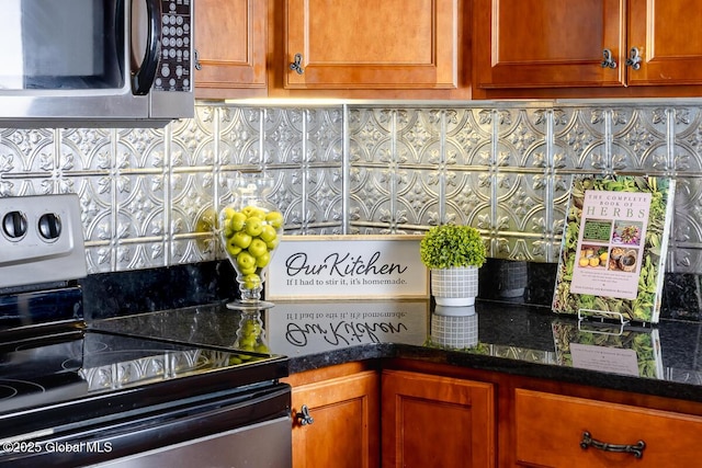 kitchen featuring dark stone counters, brown cabinets, and stainless steel appliances