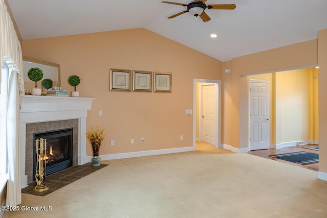 living room featuring baseboards, lofted ceiling, carpet, and a tiled fireplace