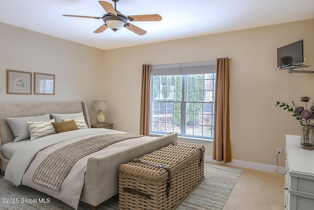 bedroom featuring baseboards, light carpet, and ceiling fan