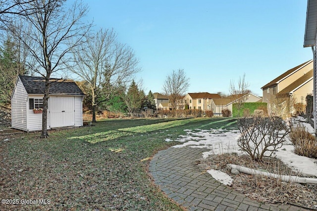 view of yard with a residential view, a storage shed, and an outdoor structure