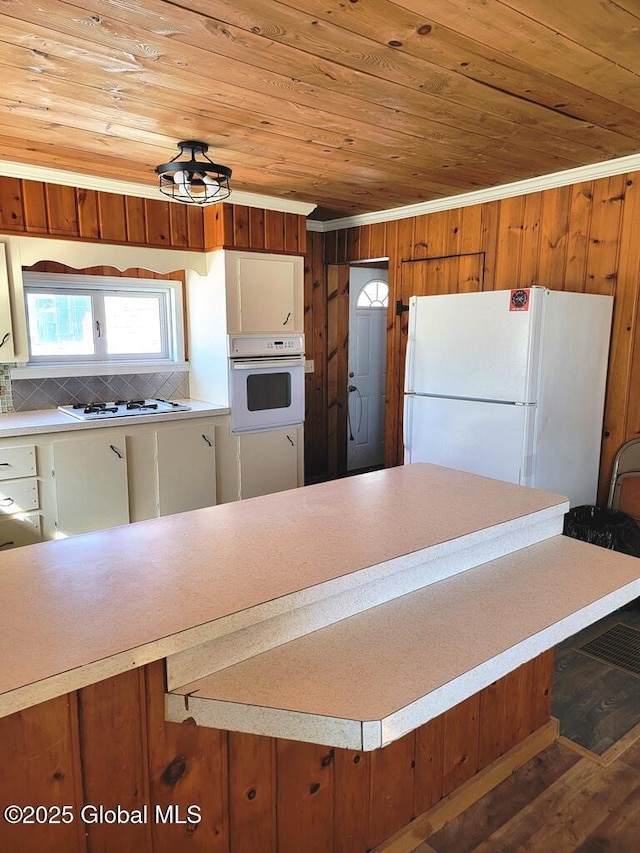 kitchen with wooden ceiling, white appliances, light countertops, and brown cabinetry