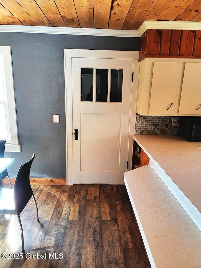 interior space featuring ornamental molding, wood ceiling, light countertops, and dark wood finished floors