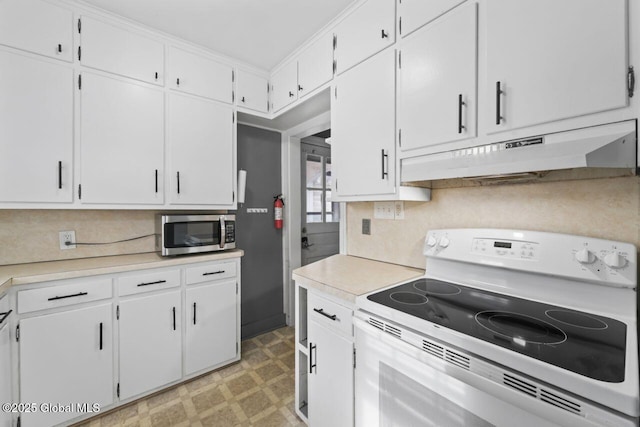 kitchen featuring white range with electric stovetop, stainless steel microwave, light floors, light countertops, and under cabinet range hood