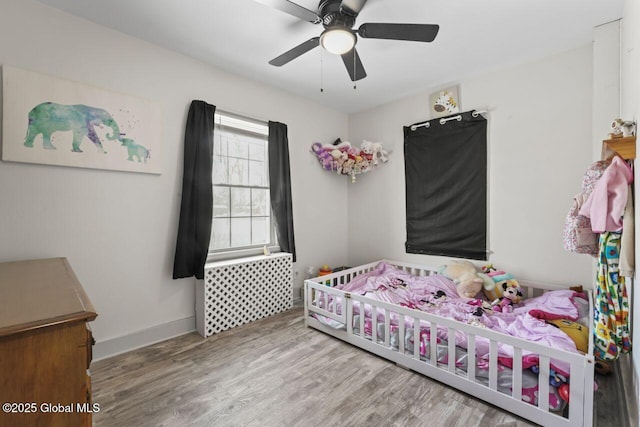 bedroom with a ceiling fan, baseboards, and wood finished floors