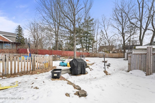 yard covered in snow with a fenced backyard