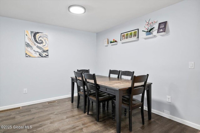 dining area with baseboards and wood finished floors