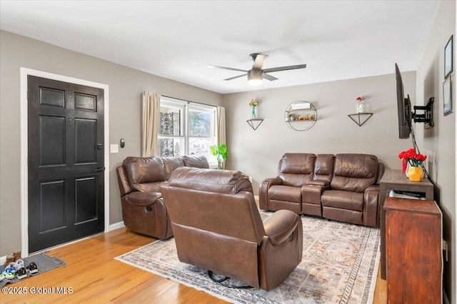 living area with a ceiling fan and light wood-style flooring