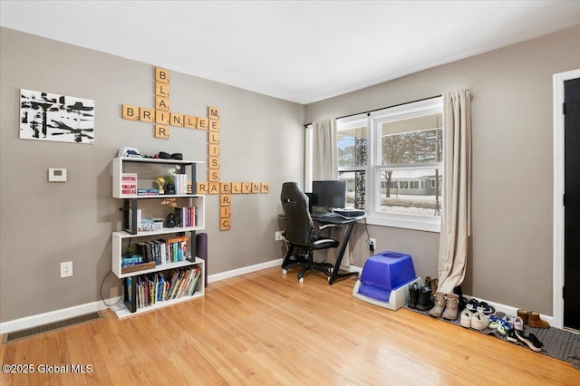 home office featuring wood finished floors, visible vents, and baseboards