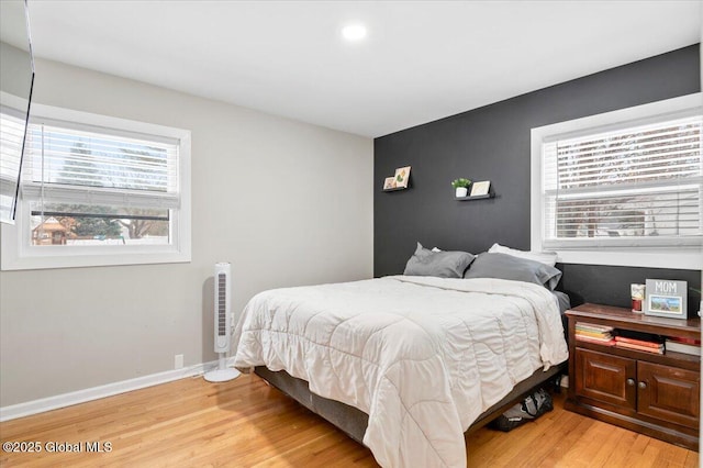 bedroom with light wood finished floors and baseboards