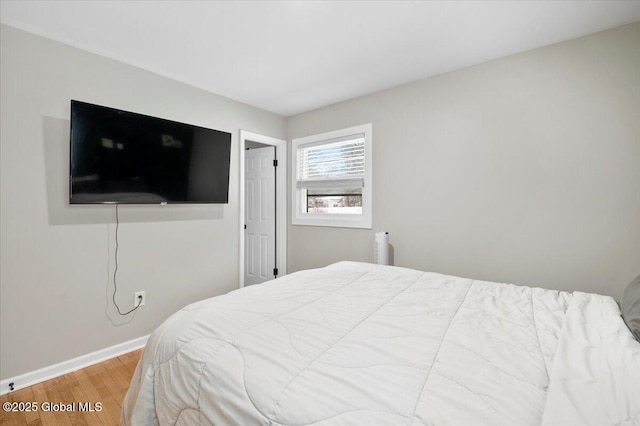 bedroom featuring baseboards and wood finished floors