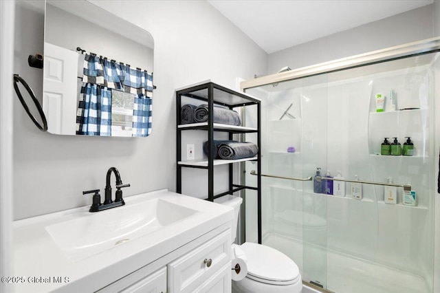 full bath featuring a stall shower, vanity, and toilet