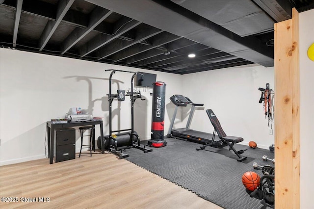 workout area with baseboards and wood finished floors