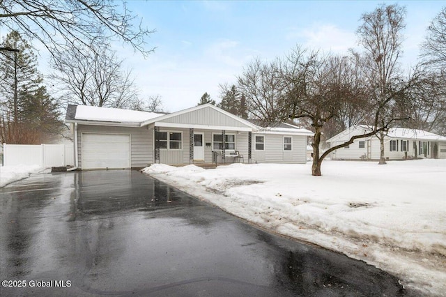 view of front of property with a garage, aphalt driveway, a chimney, and fence