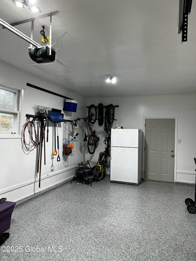 garage featuring a garage door opener and freestanding refrigerator