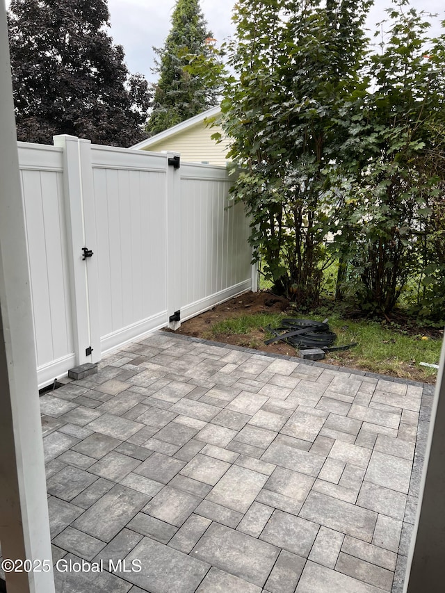 view of patio featuring fence and a gate