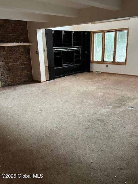 unfurnished room featuring carpet floors and beamed ceiling