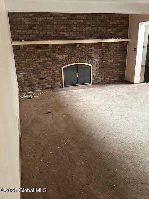 unfurnished living room with brick wall and a fireplace