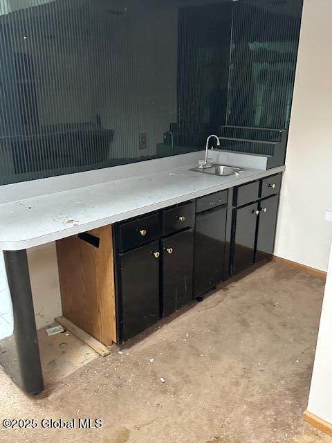 bathroom with unfinished concrete flooring, a sink, and baseboards