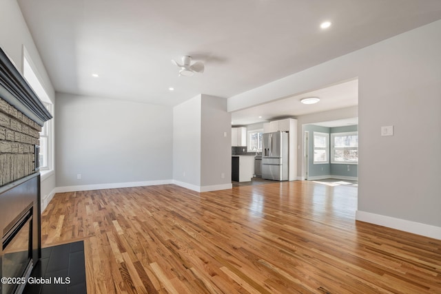 unfurnished living room featuring a ceiling fan, recessed lighting, baseboards, and light wood finished floors