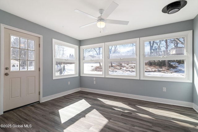 unfurnished sunroom featuring a ceiling fan and a wealth of natural light