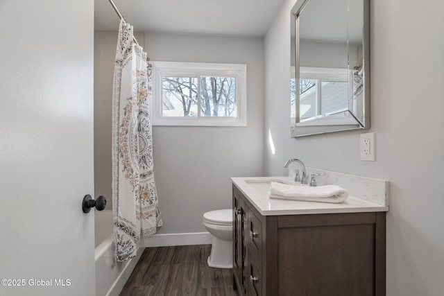 full bathroom featuring shower / tub combo, baseboards, toilet, wood finished floors, and vanity