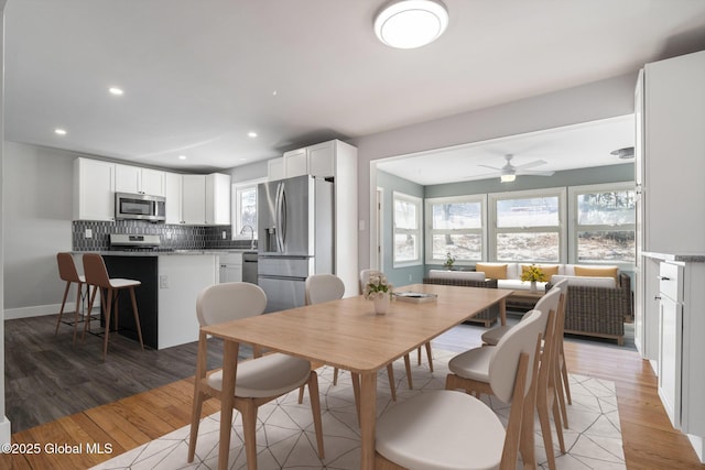 dining area featuring a healthy amount of sunlight, light wood-style flooring, and baseboards