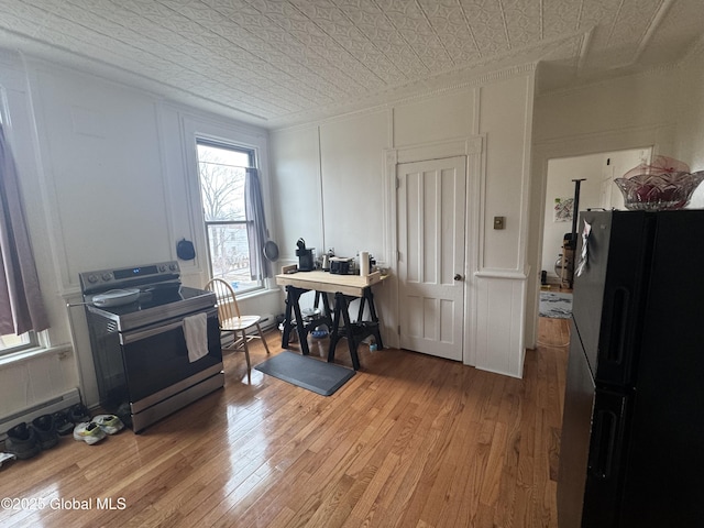 interior space with light wood finished floors, an ornate ceiling, crown molding, and a decorative wall