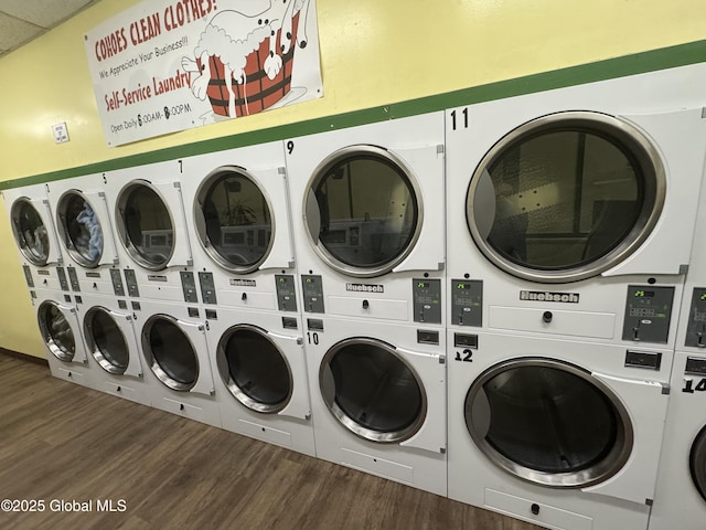 shared laundry area featuring wood finished floors, washing machine and dryer, and stacked washing maching and dryer