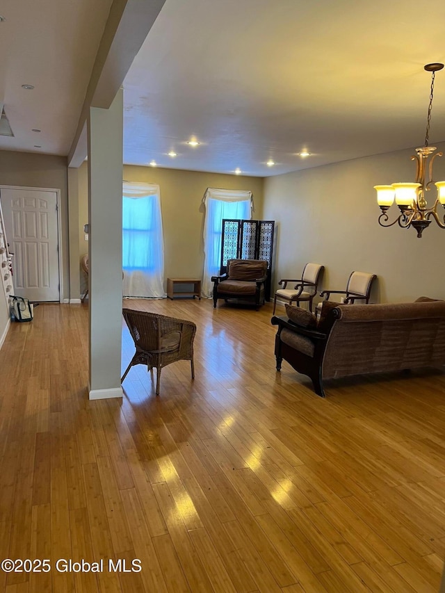 living room with wood-type flooring, a chandelier, baseboards, and recessed lighting