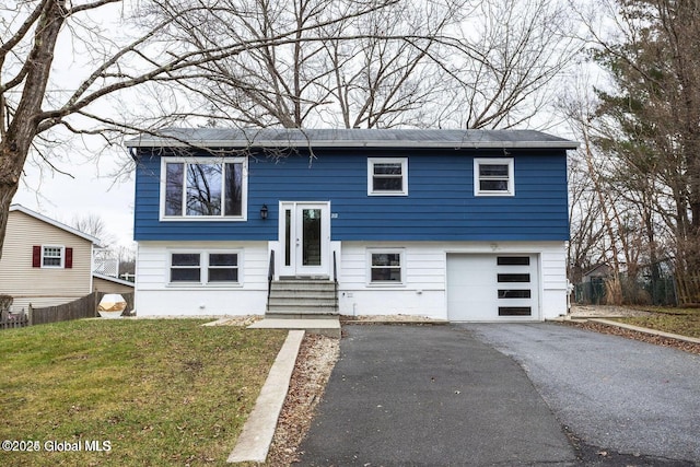 bi-level home with a garage, a front yard, and driveway