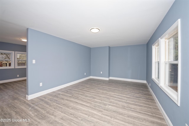 empty room featuring baseboards and wood finished floors