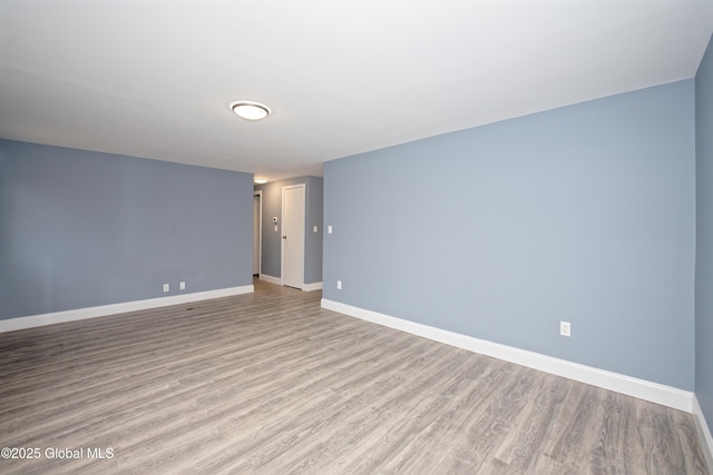 empty room featuring baseboards and wood finished floors