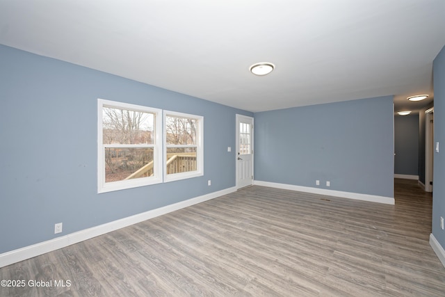 empty room featuring wood finished floors and baseboards