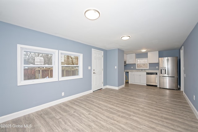 kitchen featuring stainless steel appliances, white cabinets, light wood finished floors, baseboards, and light countertops