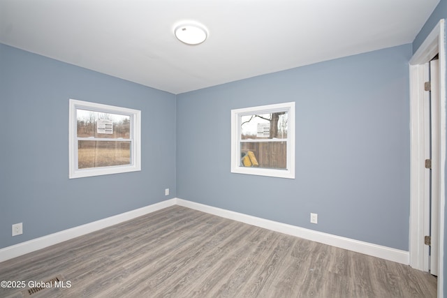 empty room with baseboards and wood finished floors