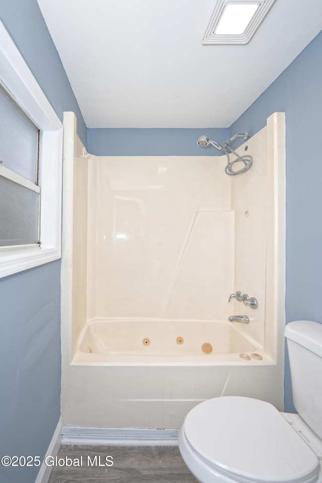 full bathroom with bathing tub / shower combination, toilet, and wood finished floors