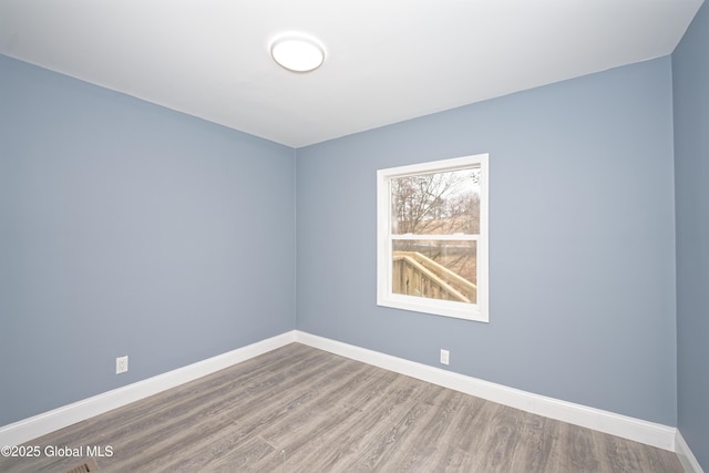 empty room featuring baseboards and wood finished floors