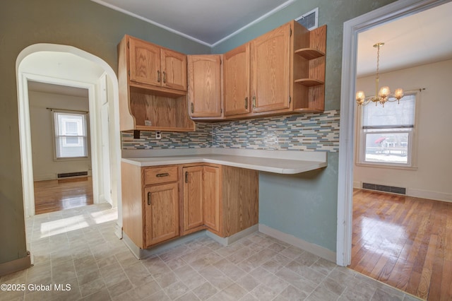 kitchen featuring an inviting chandelier, open shelves, visible vents, and backsplash