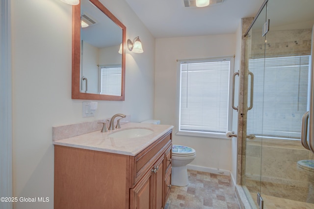 bathroom featuring vanity, baseboards, visible vents, a shower stall, and toilet