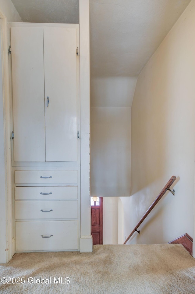 interior space with carpet floors and vaulted ceiling