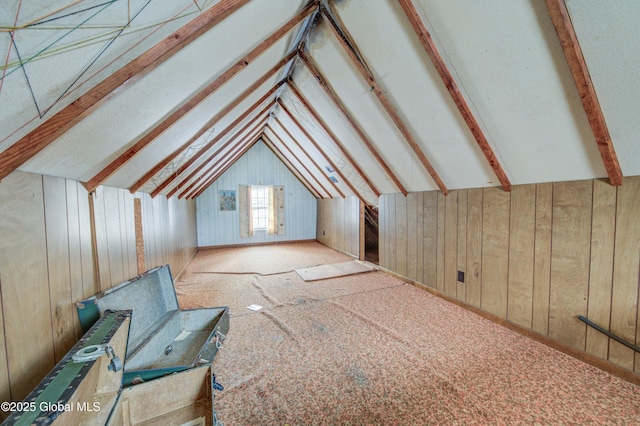 bonus room featuring wood walls and vaulted ceiling with beams