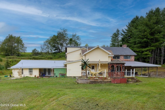 rear view of property featuring a gazebo, a chimney, french doors, and a yard