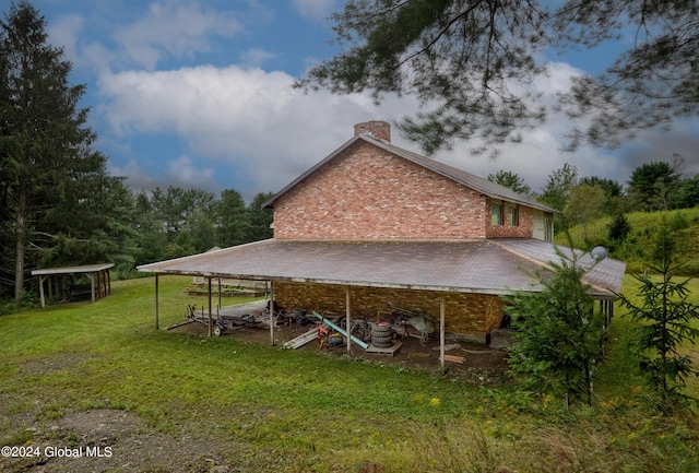 exterior space featuring a chimney and a lawn