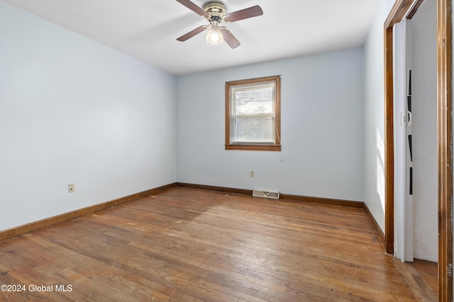 spare room featuring light wood-type flooring, visible vents, ceiling fan, and baseboards