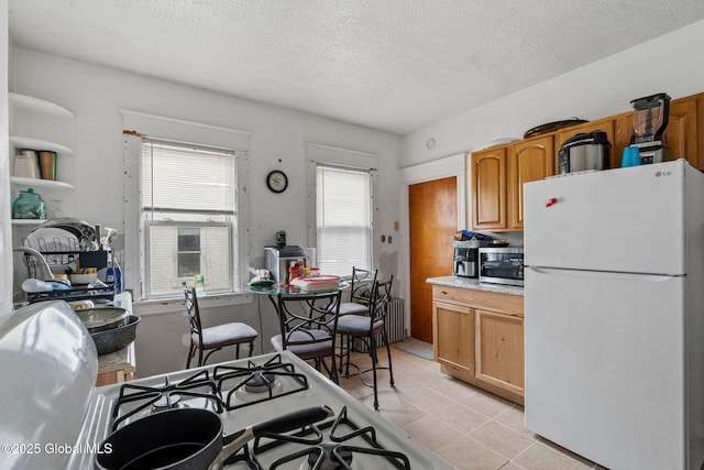 kitchen featuring white appliances, light tile patterned floors, light countertops, and a textured ceiling