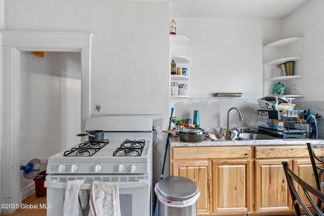 kitchen featuring open shelves, white gas range oven, and a sink